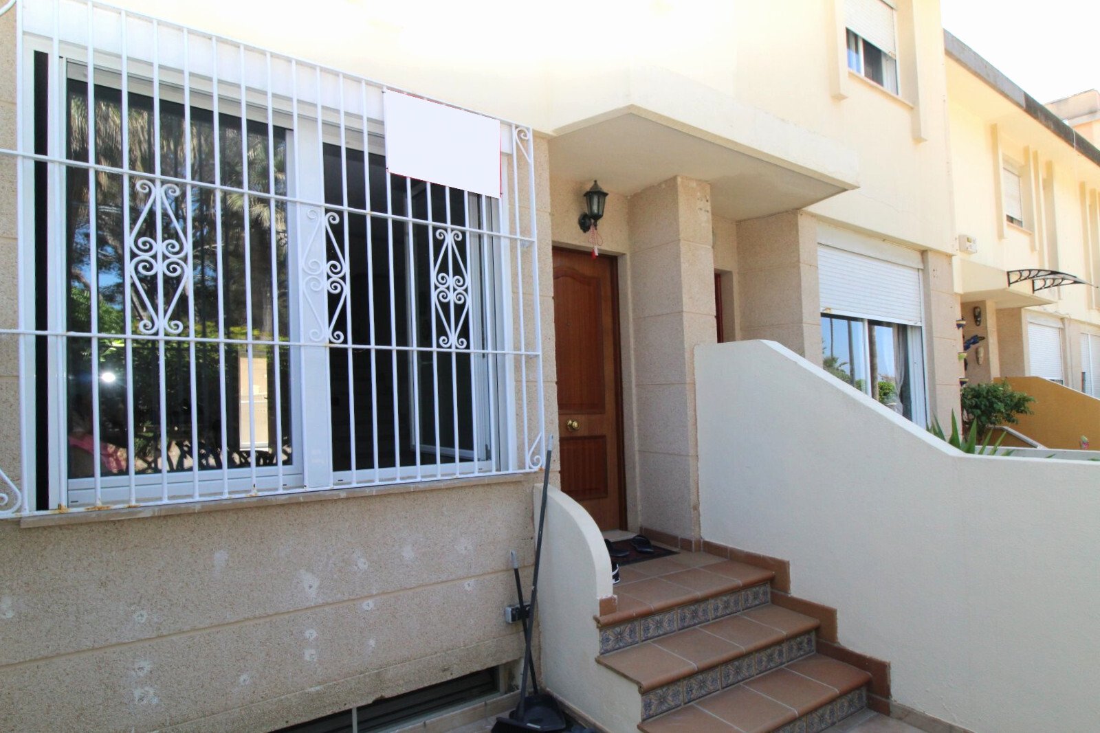 Secure house entrance with solid protective grille system and covered access area Secure house entrance with solid protective grille system and covered access area