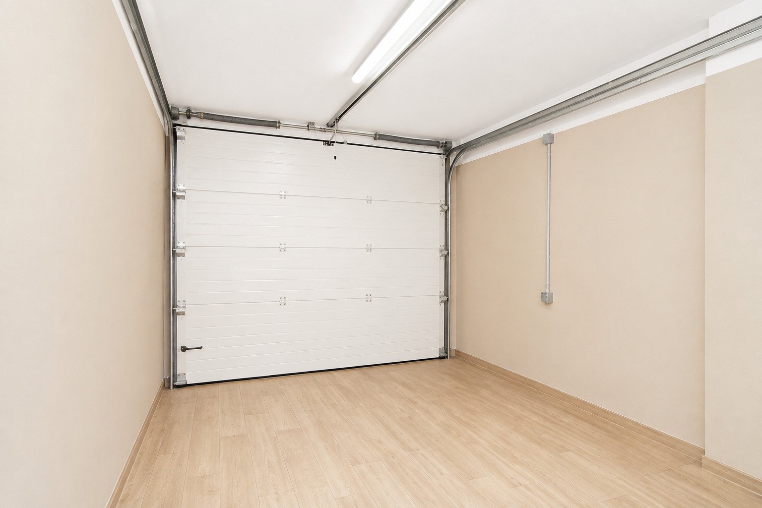 Functional garage with automatic sectional door and level floor.