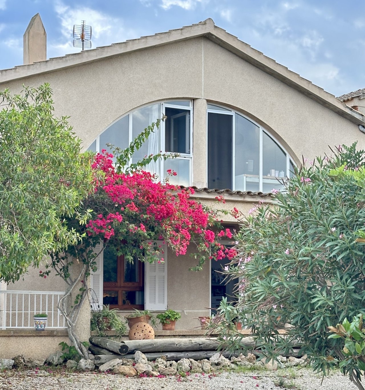 A characterful residential building with large rounded arch windows and a terrace.
