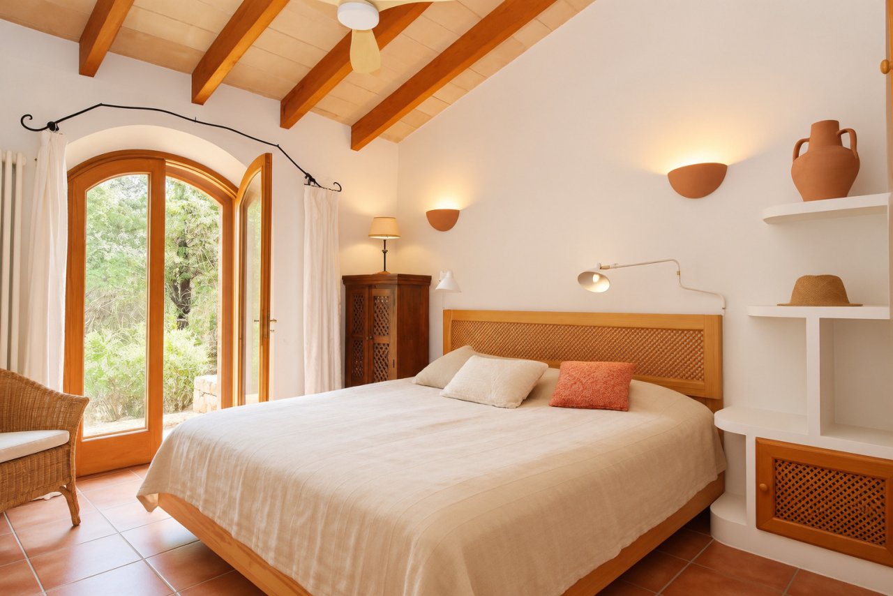 Main bedroom with wooden beam ceiling, arched doors to the garden Main bedroom with wooden beam ceiling, arched doors to the garden