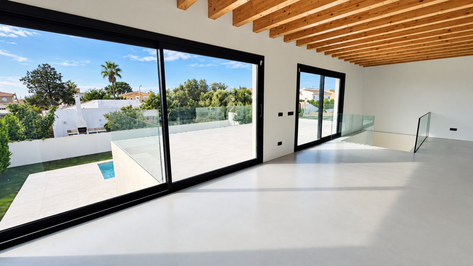 Bright living area with floor-to-ceiling sliding glass doors and exposed ceiling beams Bright living area with floor-to-ceiling sliding glass doors and exposed ceiling beams
