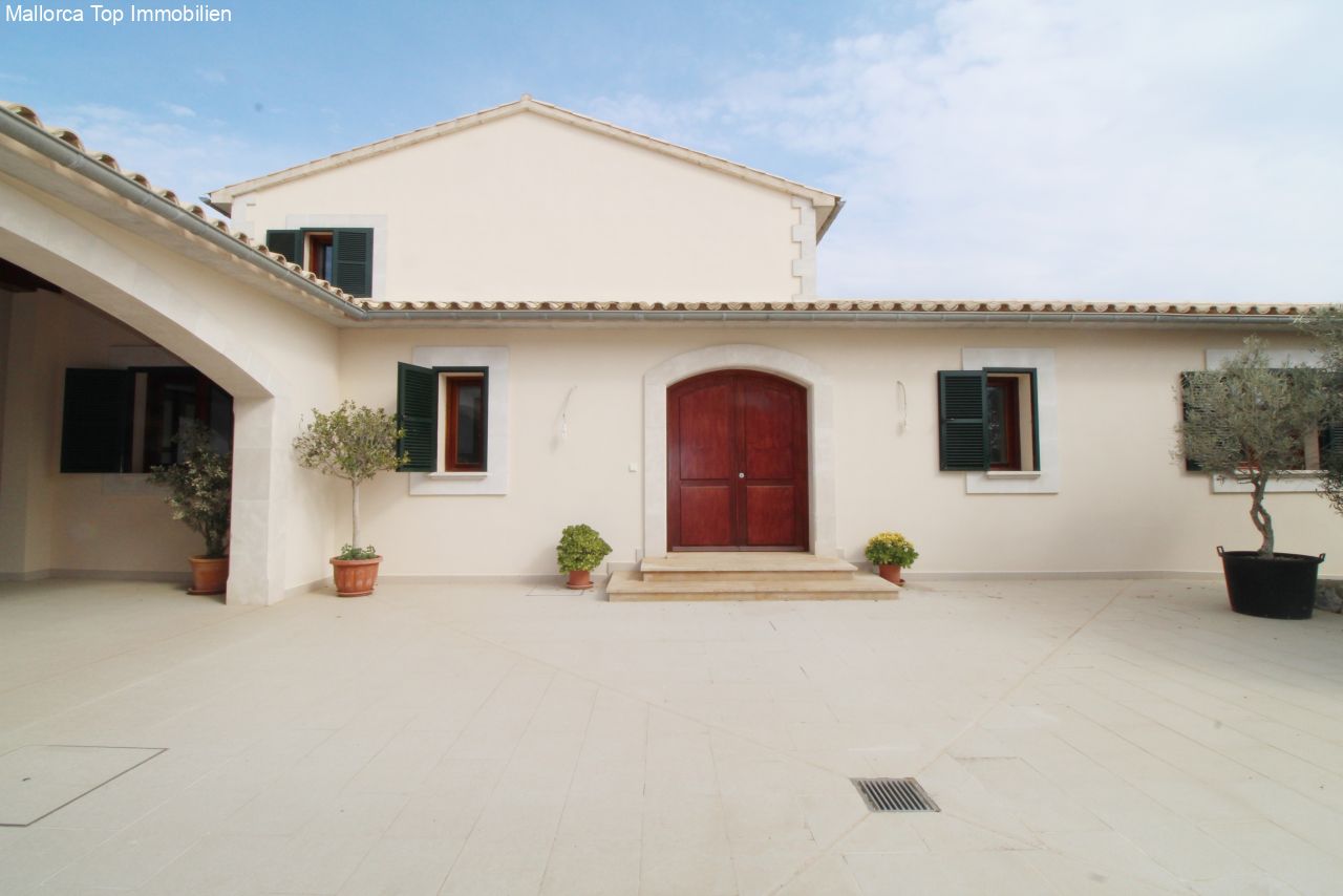 Representative entrance facade with covered carport area and spacious courtyard