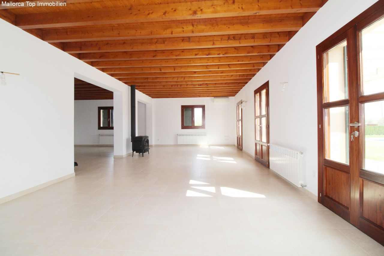 Flooded living area with rustic wooden beams and direct terrace access