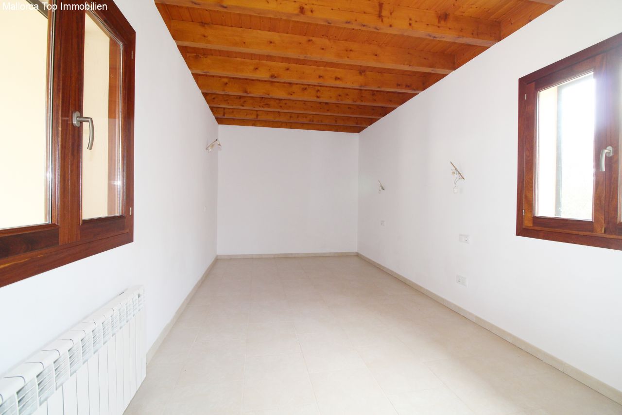 Bright bedroom with rustic wooden beam ceiling and double window front