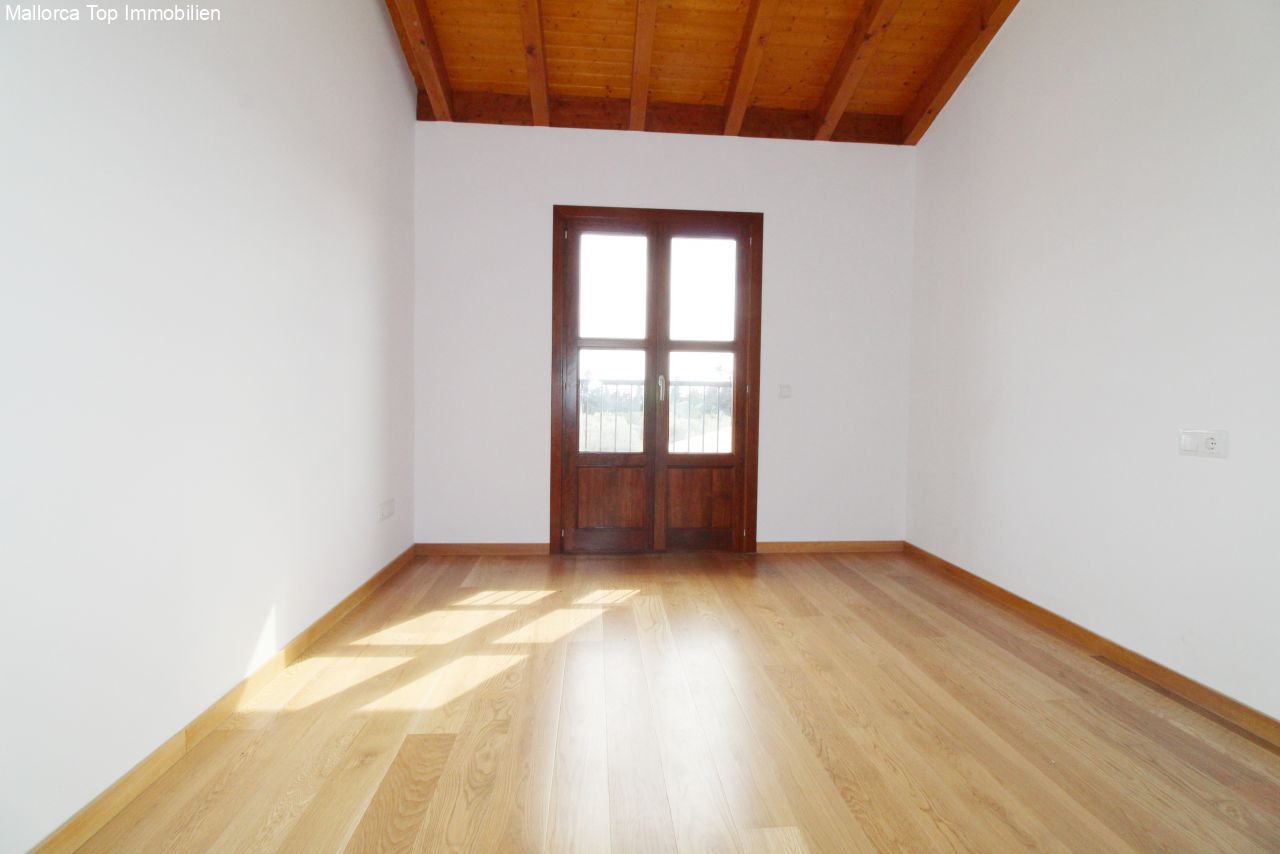 A light-filled room with a characterful wooden beam ceiling and French glass doors to the outdoor area.
