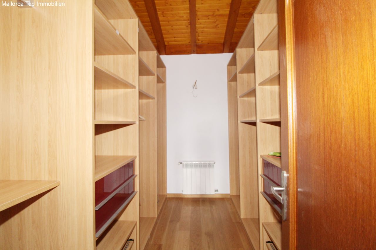 Walk-in closet with intelligent storage solution and wooden beam ceiling