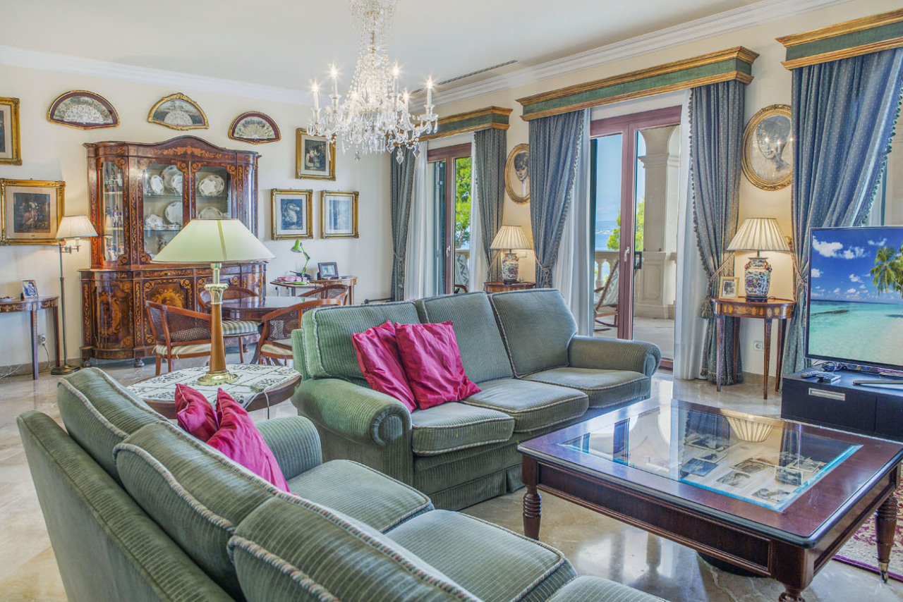 Elegant living room with crystal chandelier and direct terrace access – impressive room layout with sea view Elegant living room with crystal chandelier and direct terrace access – impressive room layout with sea view