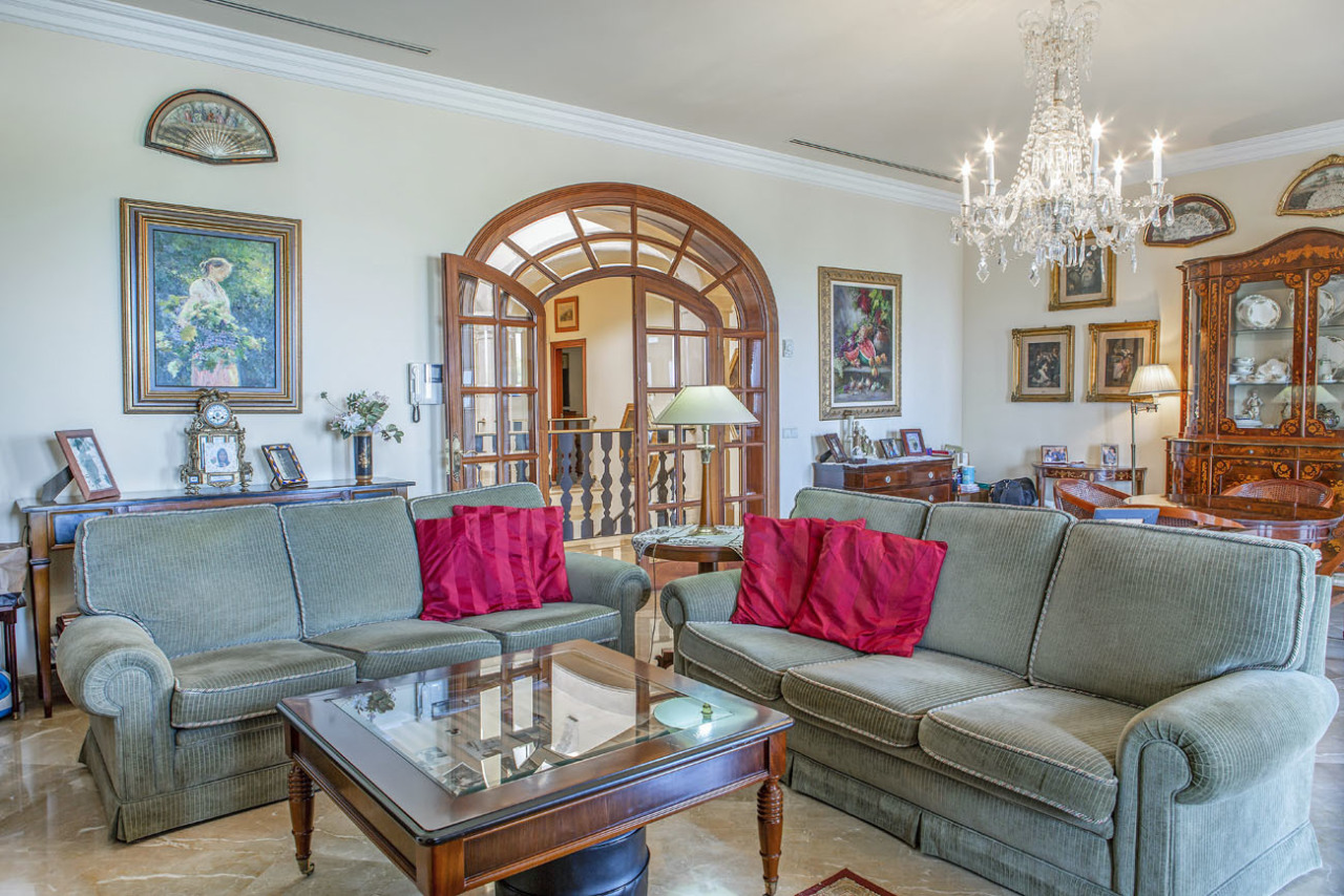 Representative living room with crystal chandelier and elegant room connection – classic architecture with rounded arch doors Representative living room with crystal chandelier and elegant room connection – classic architecture with rounded arch doors