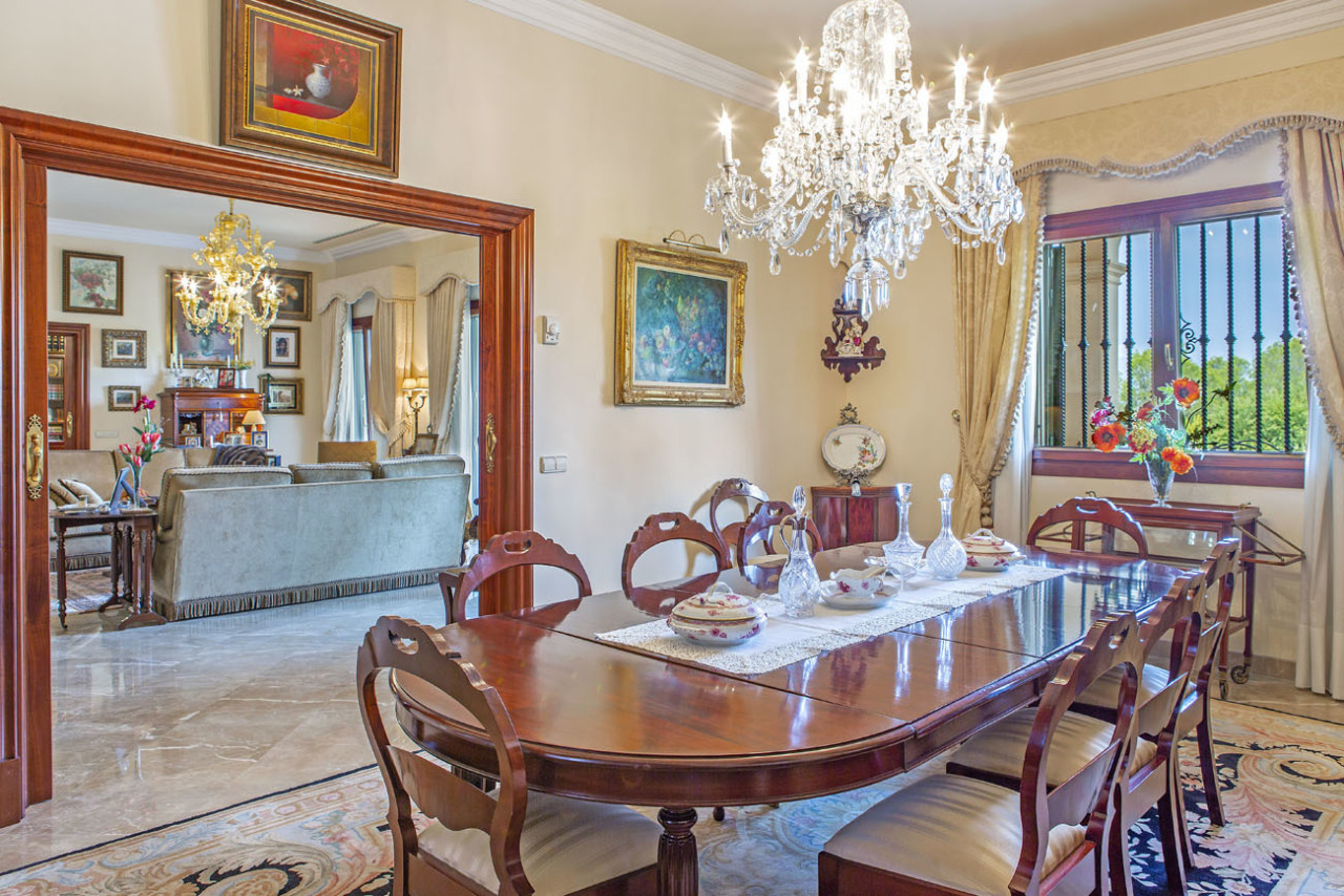 Elegant dining room with crystal chandelier and open space connection – representative table culture with direct access to the living area Elegant dining room with crystal chandelier and open space connection – representative table culture with direct access to the living area