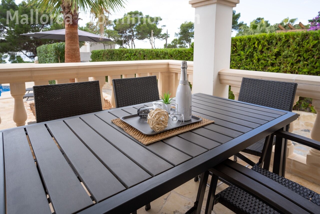 Covered dining loggia with elegant balustrade and sea view