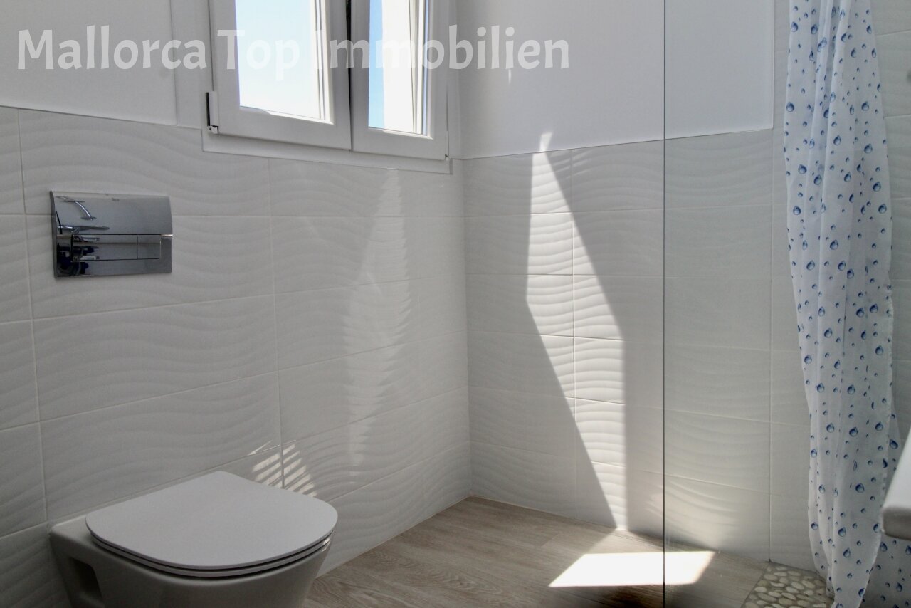 Modern bathroom with walk-in shower and large window front Modern bathroom with walk-in shower and large window front