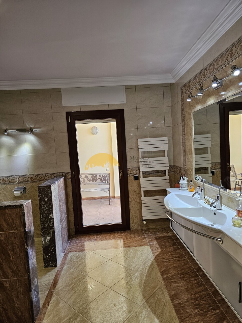 Masterfully designed bathroom with double vanity and large marble wall covering – comfort for two Masterfully designed bathroom with double vanity and large marble wall covering – comfort for two