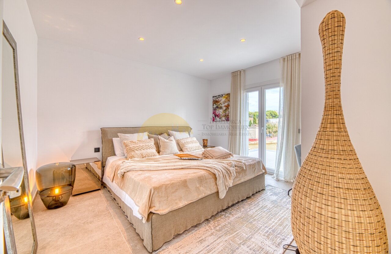 Bright bedroom with floor-to-ceiling glass doors, built-in lighting, and spacious layout.