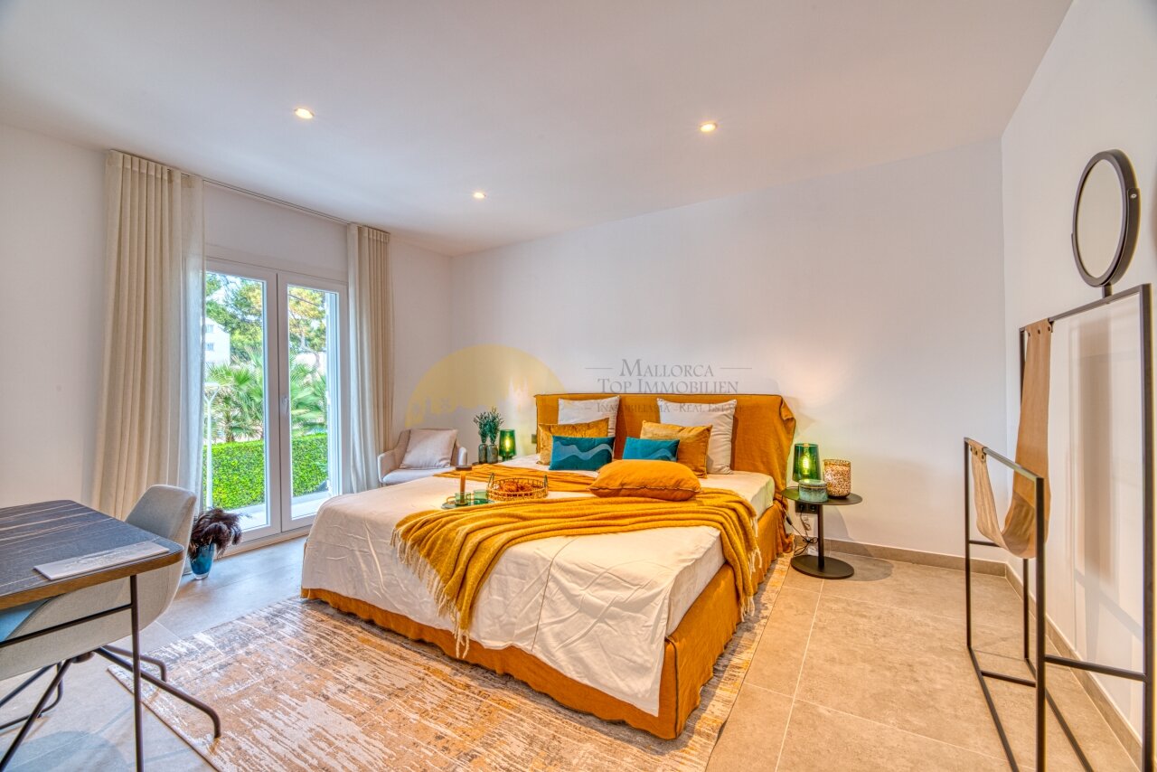 Elegant bedroom with floor-to-ceiling glass doors, built-in lighting, and spacious layout
