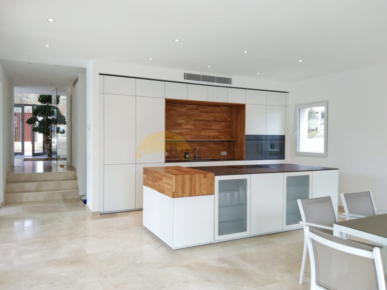 Modern kitchen with a central island and extensive storage solutions Modern kitchen with a central island and extensive storage solutions