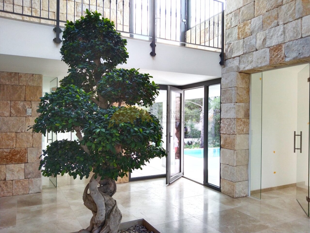 Atrium with double-height ceiling and large glass sliding doors to the pool area Atrium with double-height ceiling and large glass sliding doors to the pool area