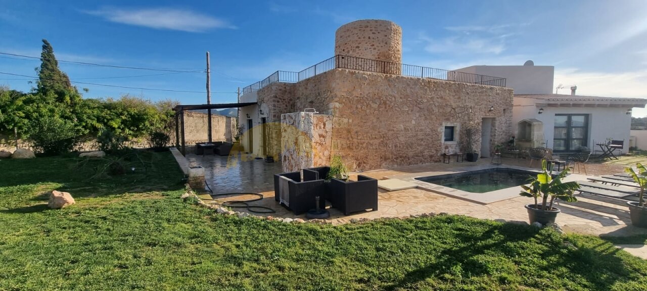 Idyllic outdoor area with pool, natural stone tower, and spacious garden. Idyllic outdoor area with pool, natural stone tower, and spacious garden.