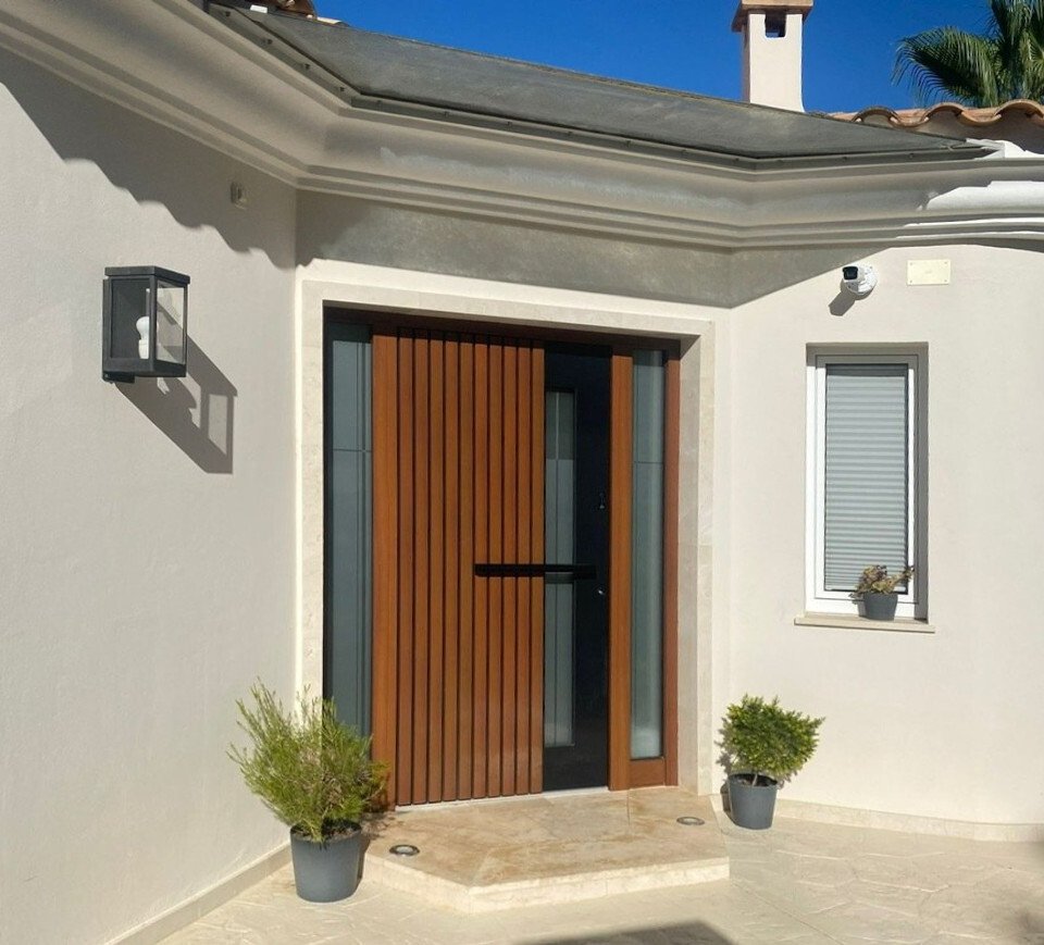 Modern entrance area with high-quality sliding door construction and covered entrance terrace