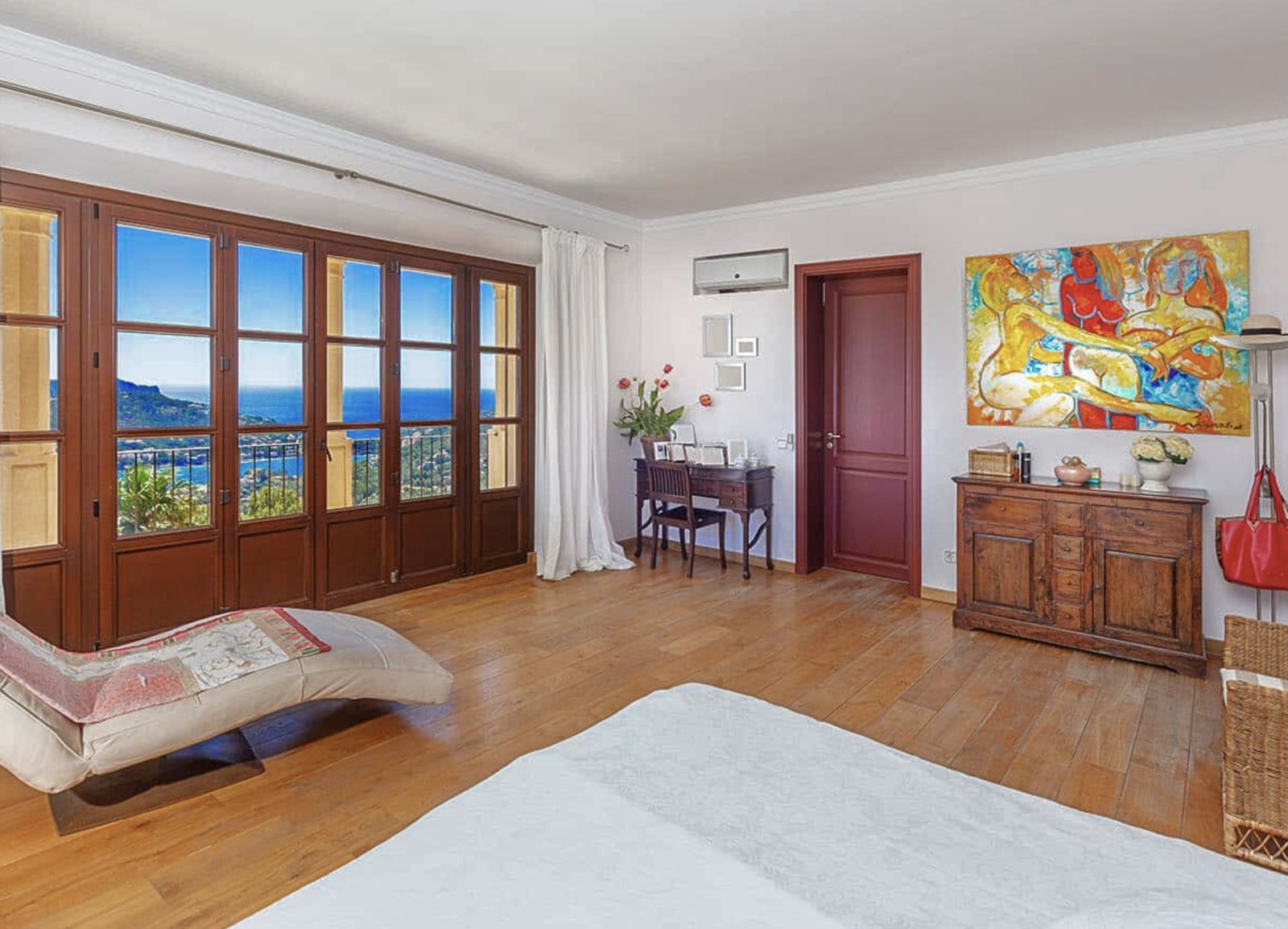 Main bedroom with panoramic sea-view windows and flexible room layout for a workspace