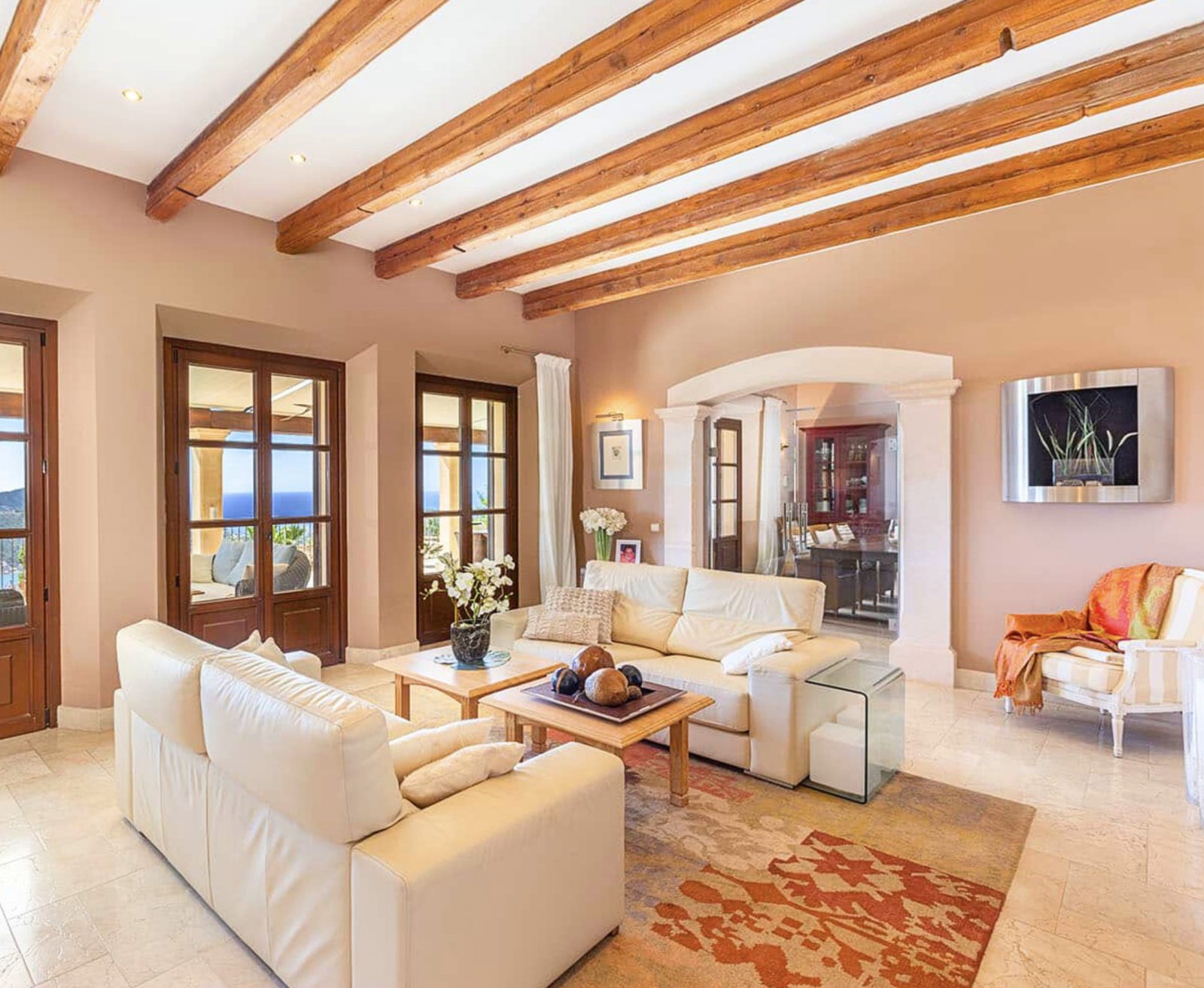 A characterful living room with rustic ceiling beams and elegant rounded arch openings