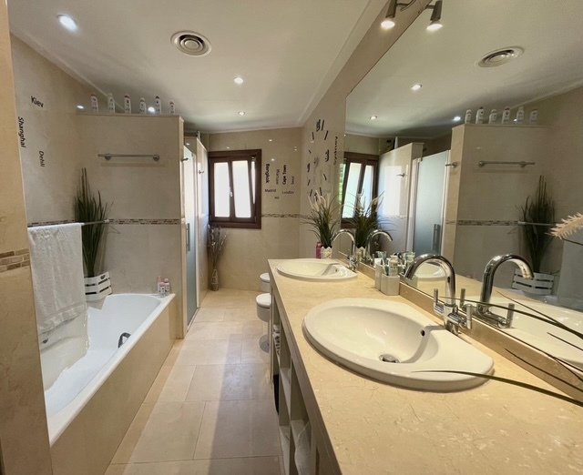 Luxurious double sink bathroom with walk-in shower and professional lighting Luxurious double sink bathroom with walk-in shower and professional lighting