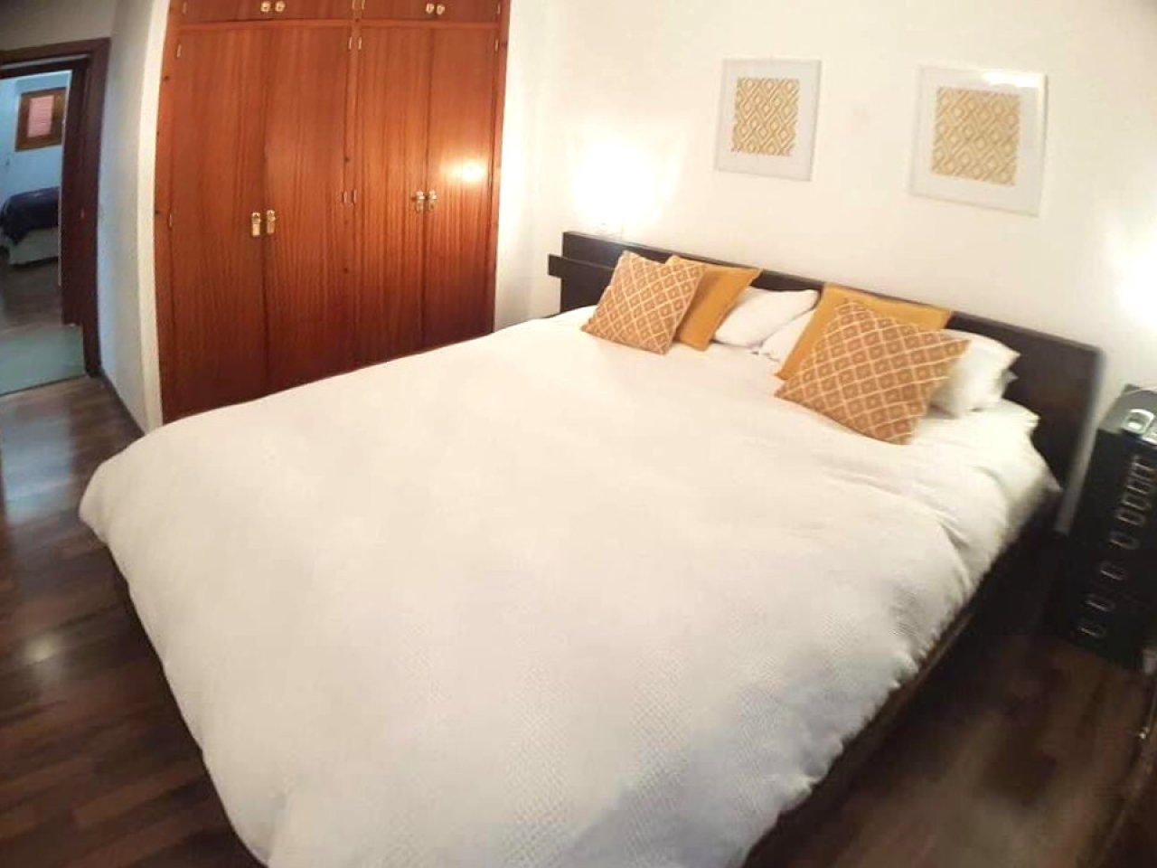 Spacious bedroom with parquet flooring and extensive wardrobe system Spacious bedroom with parquet flooring and extensive wardrobe system