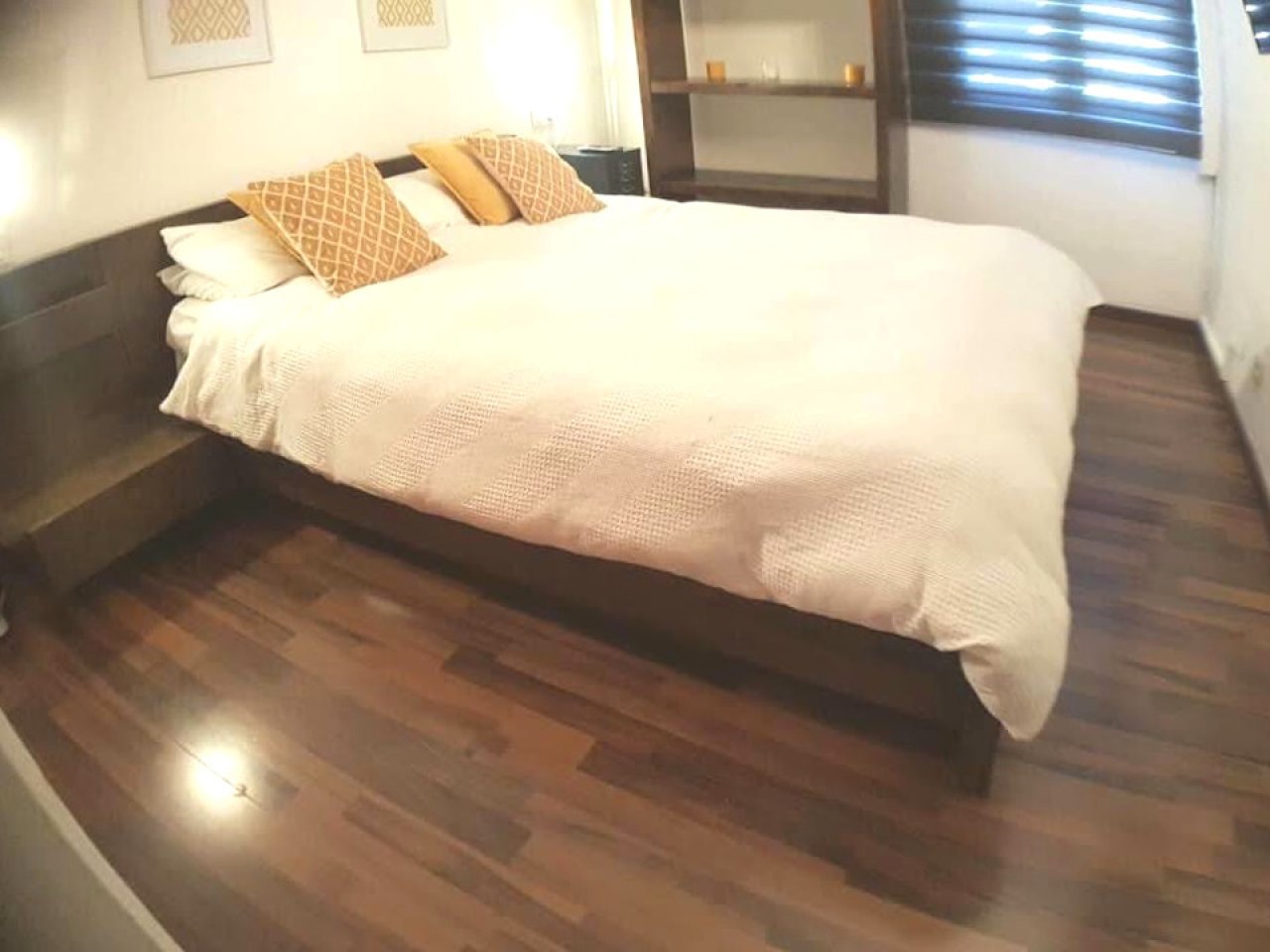Comfortable bedroom with parquet flooring and built-in wardrobe system Comfortable bedroom with parquet flooring and built-in wardrobe system