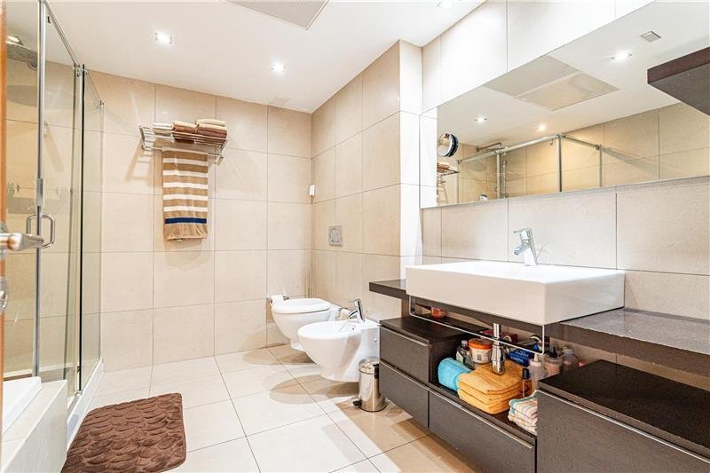Modern bathroom with separate toilet, large washbasin, and walk-in shower
