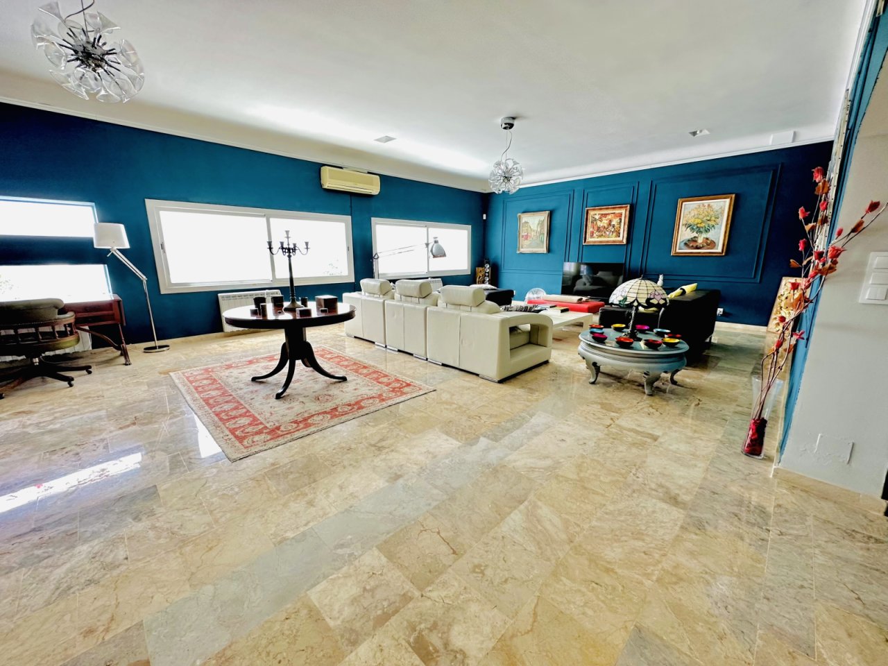 Elegant living room with marble flooring and large window wall
