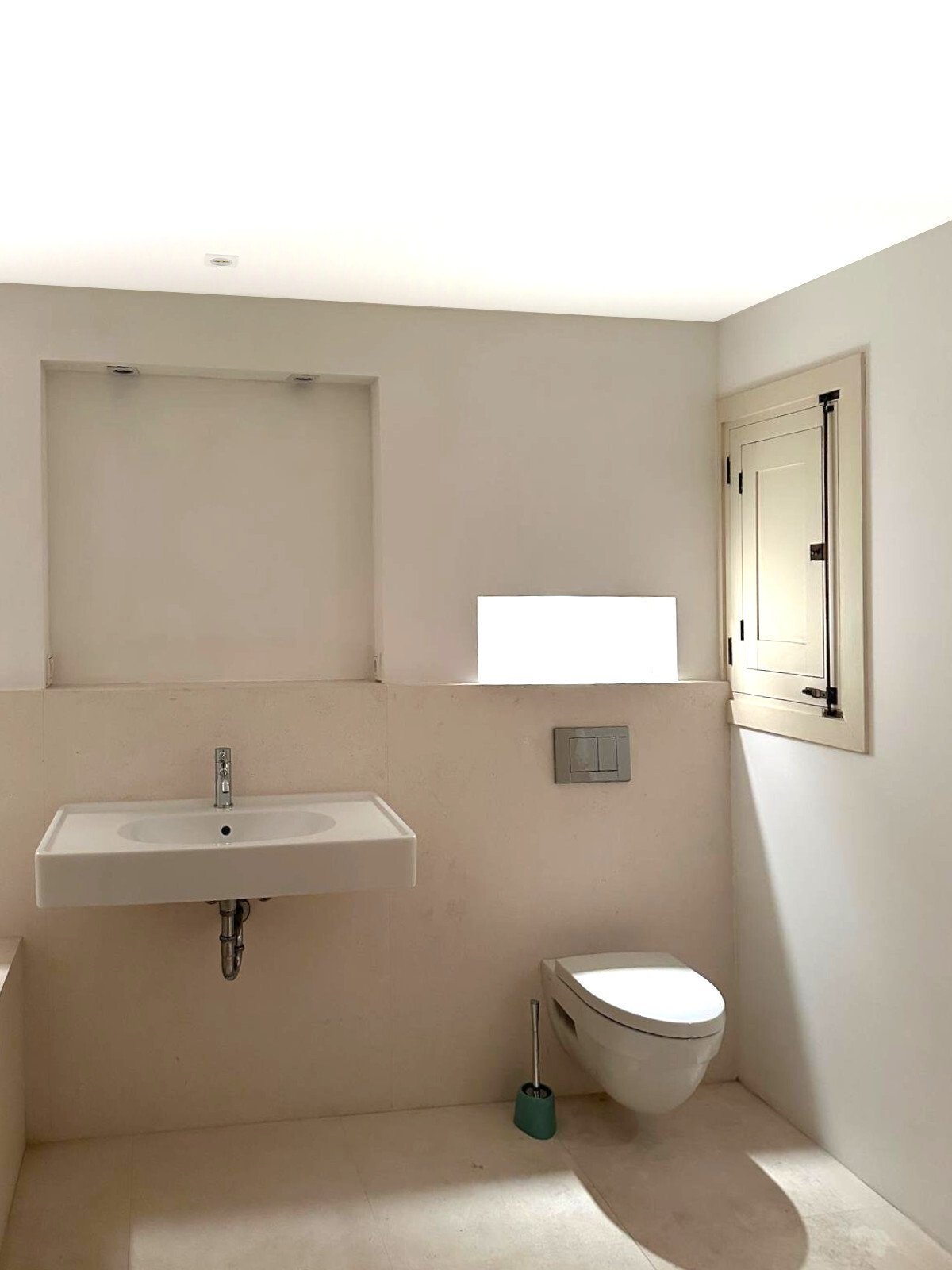 Modern guest toilet with wall-mounted toilet and large mirror