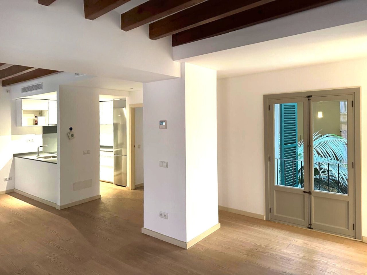 Open living concept with balcony access and distinctive wooden beams