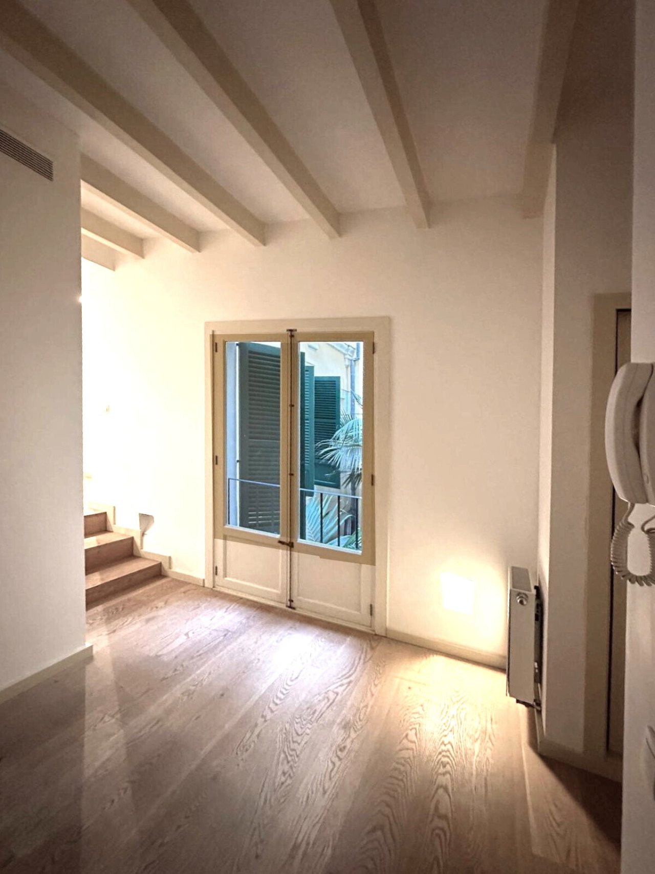 Bright living area with direct terrace access and elegant ceiling beams