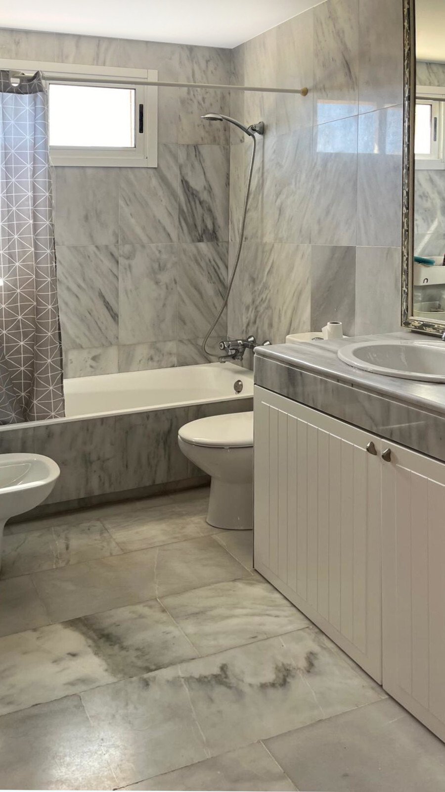 Modern bathroom with walk-in shower, marble wall cladding, and large skylights Modern bathroom with walk-in shower, marble wall cladding, and large skylights
