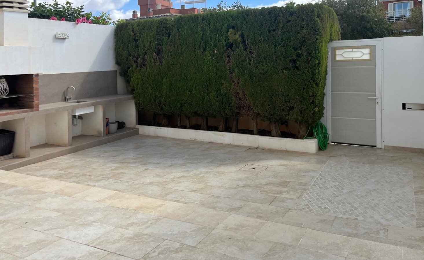 Outdoor kitchen with integrated grill and direct connection to the terrace area Outdoor kitchen with integrated grill and direct connection to the terrace area