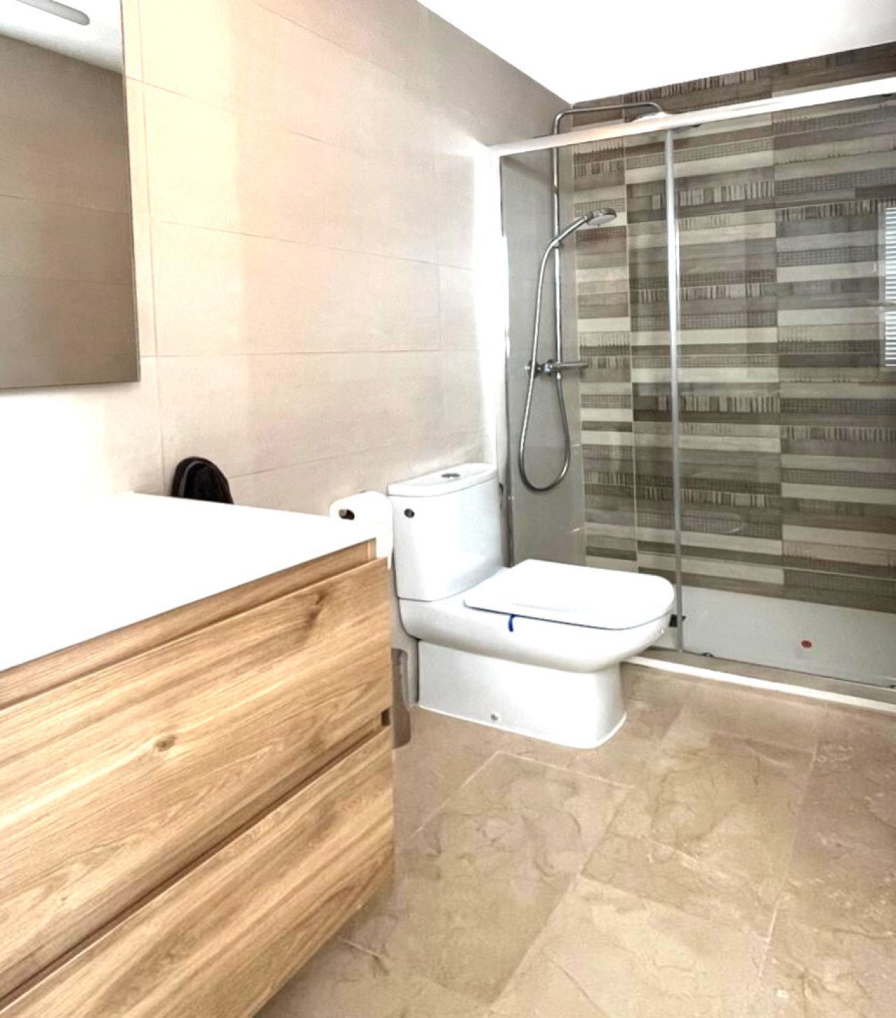 Modern bathroom with walk-in shower, glass partition, and high-quality tile design Modern bathroom with walk-in shower, glass partition, and high-quality tile design