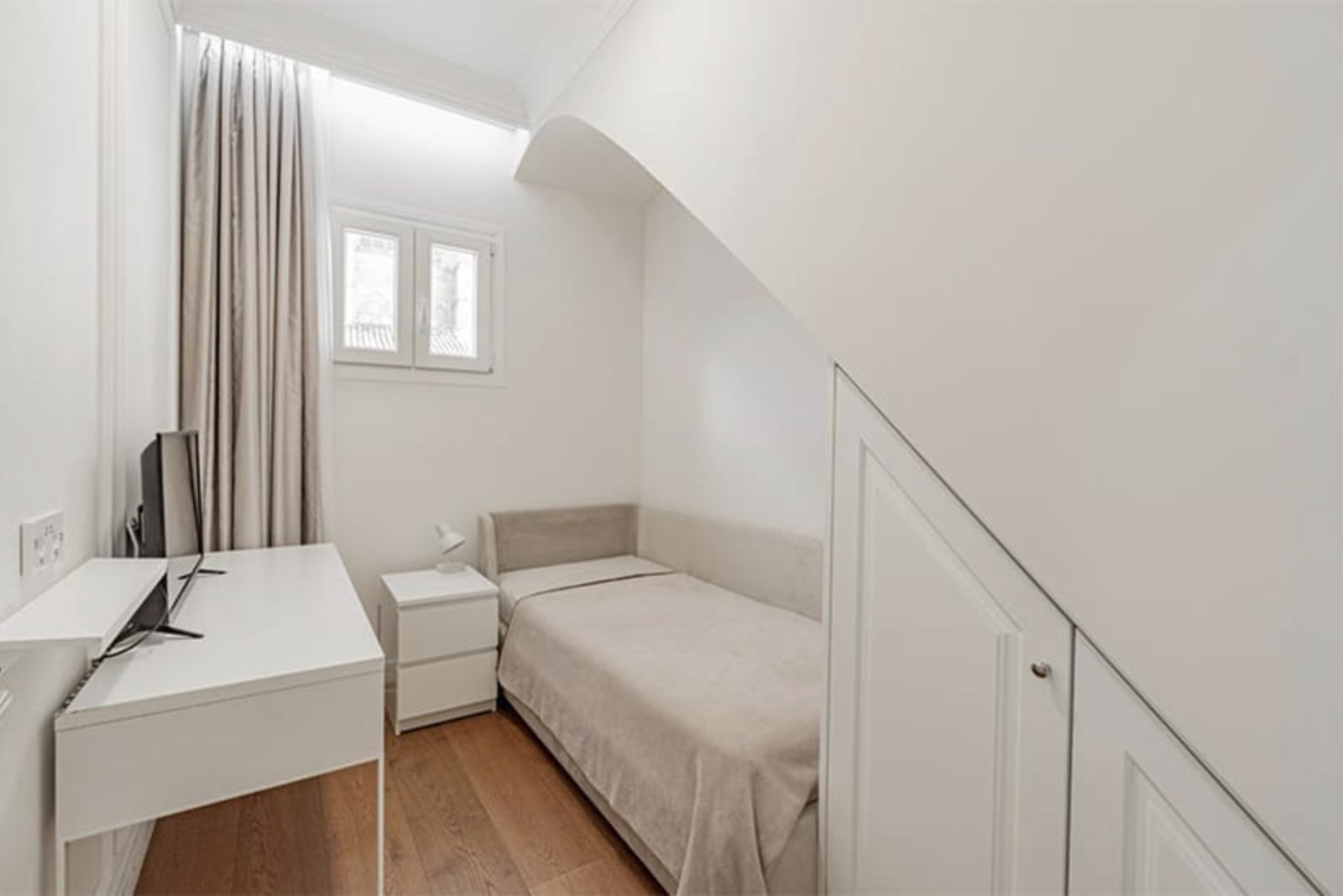 Compact attic room with efficient space utilization and roof slope integration
