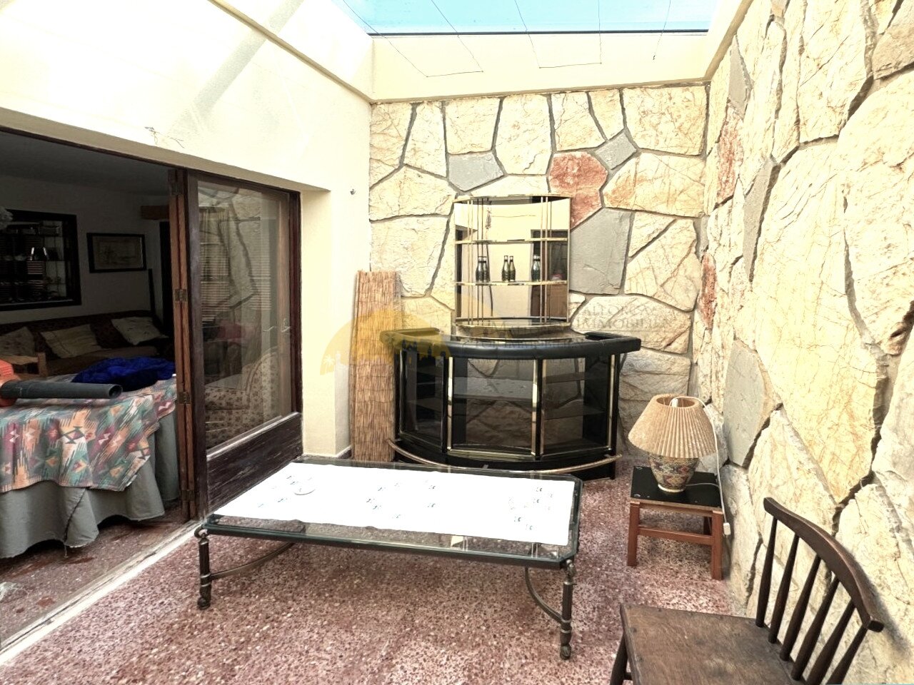 Living area with wood stove and generous ceiling height under glass roof structure Living area with wood stove and generous ceiling height under glass roof structure