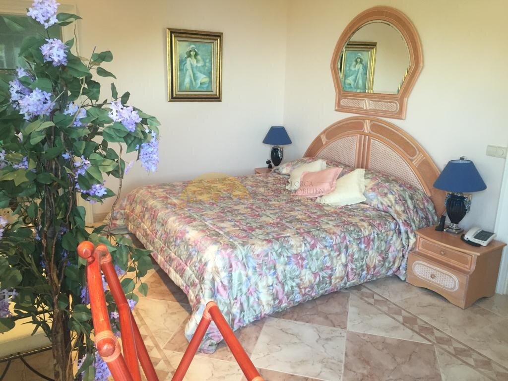 Comfortable master bedroom with marble flooring and large window front.