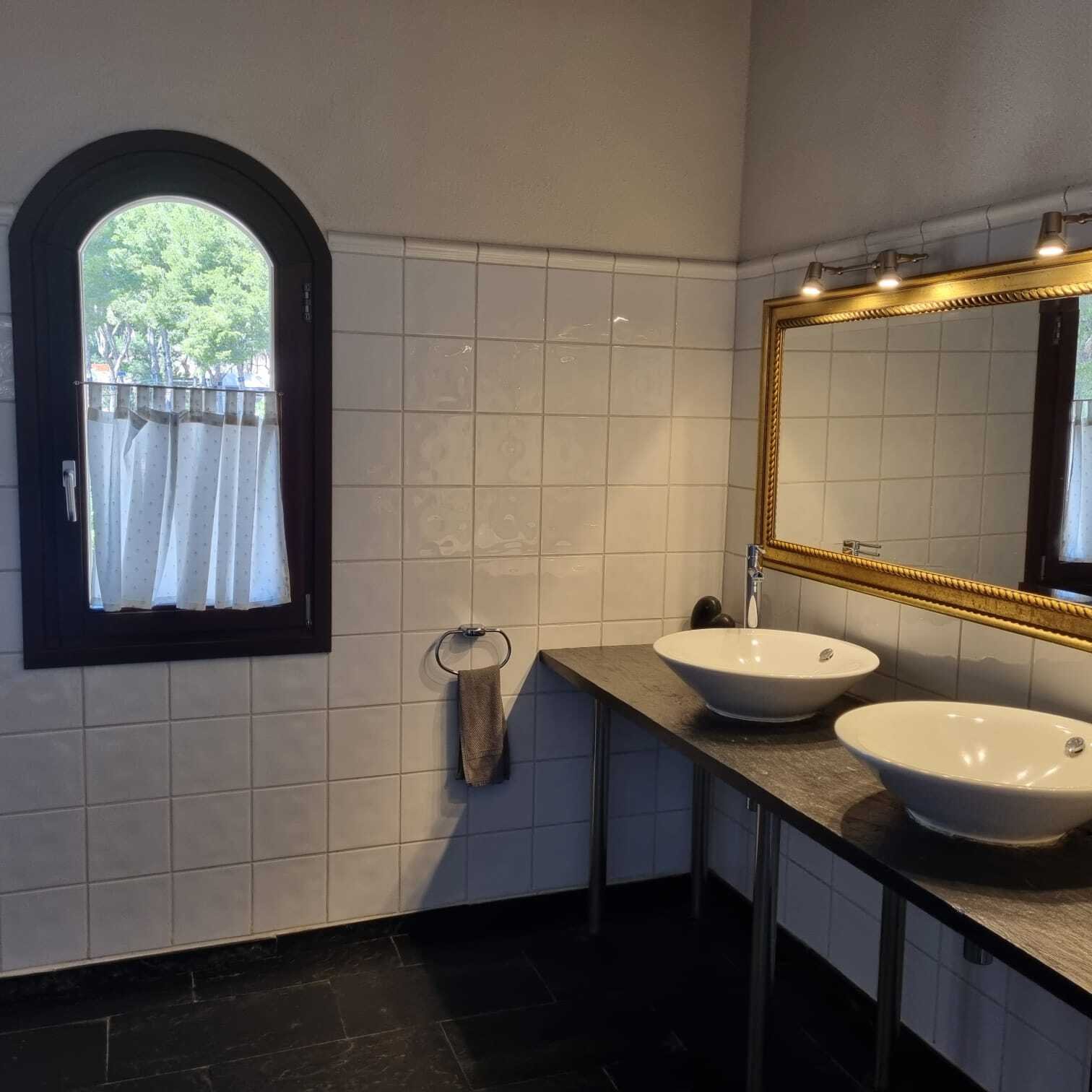 Elegant bathroom with double sink, sash window, and high-quality mirror lighting Elegant bathroom with double sink, sash window, and high-quality mirror lighting