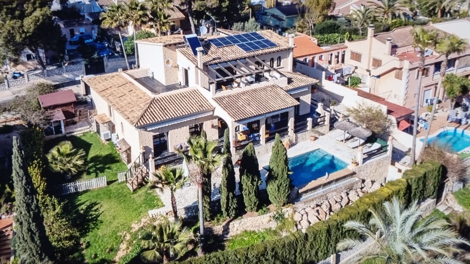 Aerial view: Modern villa with pool, solar system, and Mediterranean-style property Aerial view: Modern villa with pool, solar system, and Mediterranean-style property