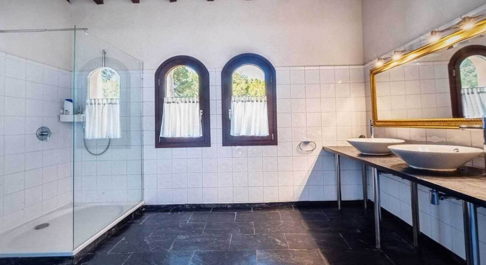 Luxurious bathroom with walk-in shower, double vanity, and sash windows with a view Luxurious bathroom with walk-in shower, double vanity, and sash windows with a view