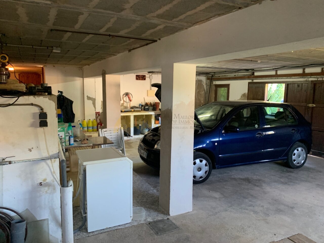 Practical garage with parking spaces and workshop area Practical garage with parking spaces and workshop area