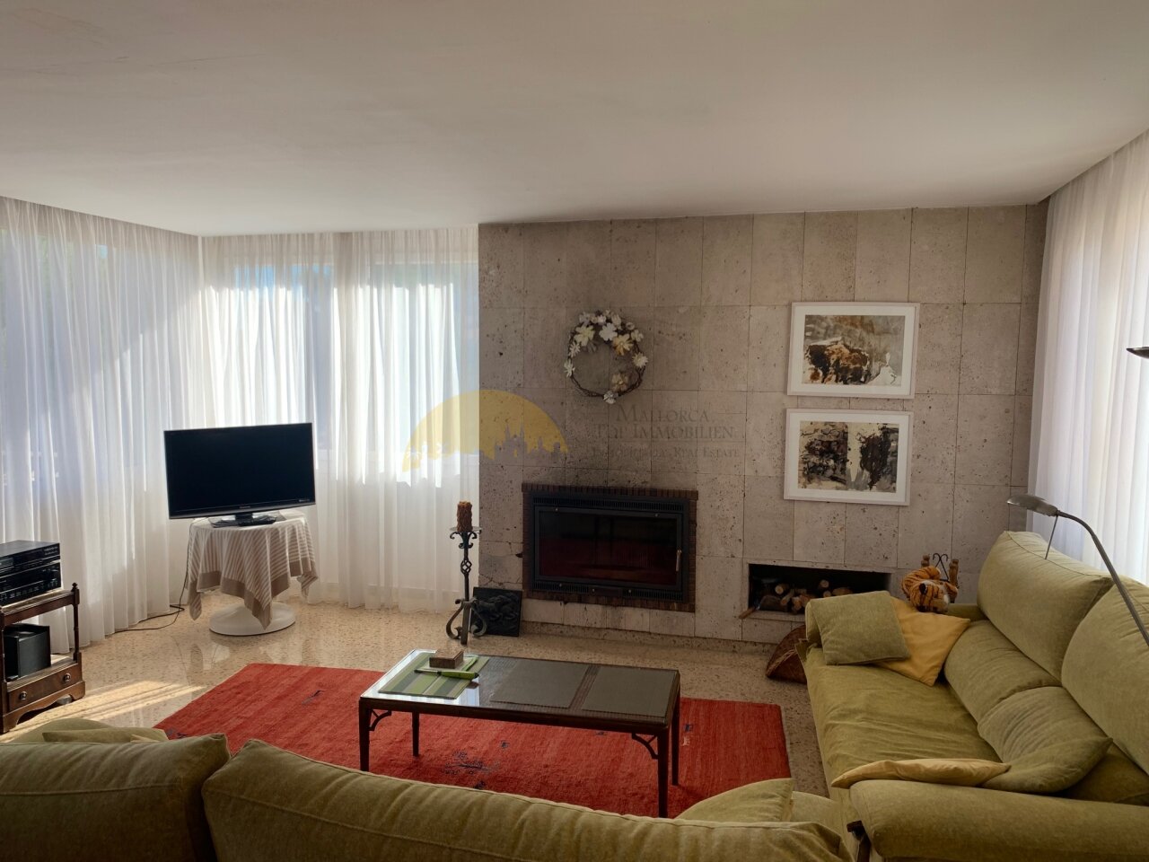 Living room with a fireplace and floor-to-ceiling windows. Living room with a fireplace and floor-to-ceiling windows.
