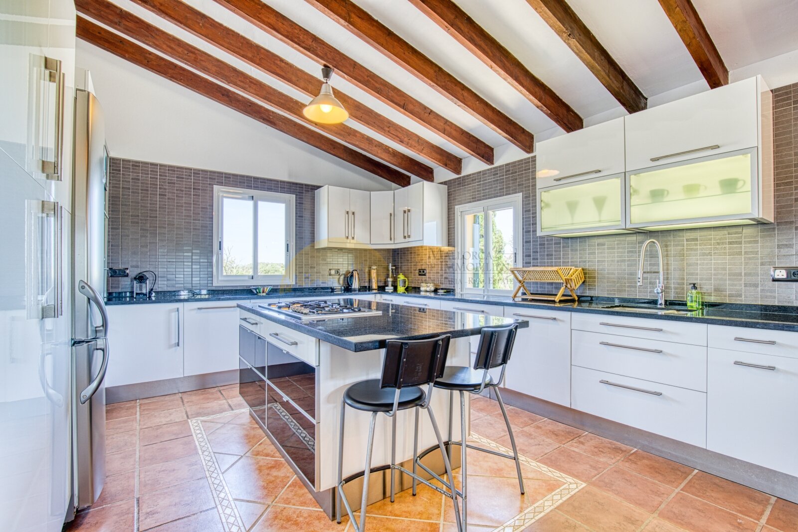 Modern kitchen with island, high-quality countertops, and elegant ceiling beams Modern kitchen with island, high-quality countertops, and elegant ceiling beams