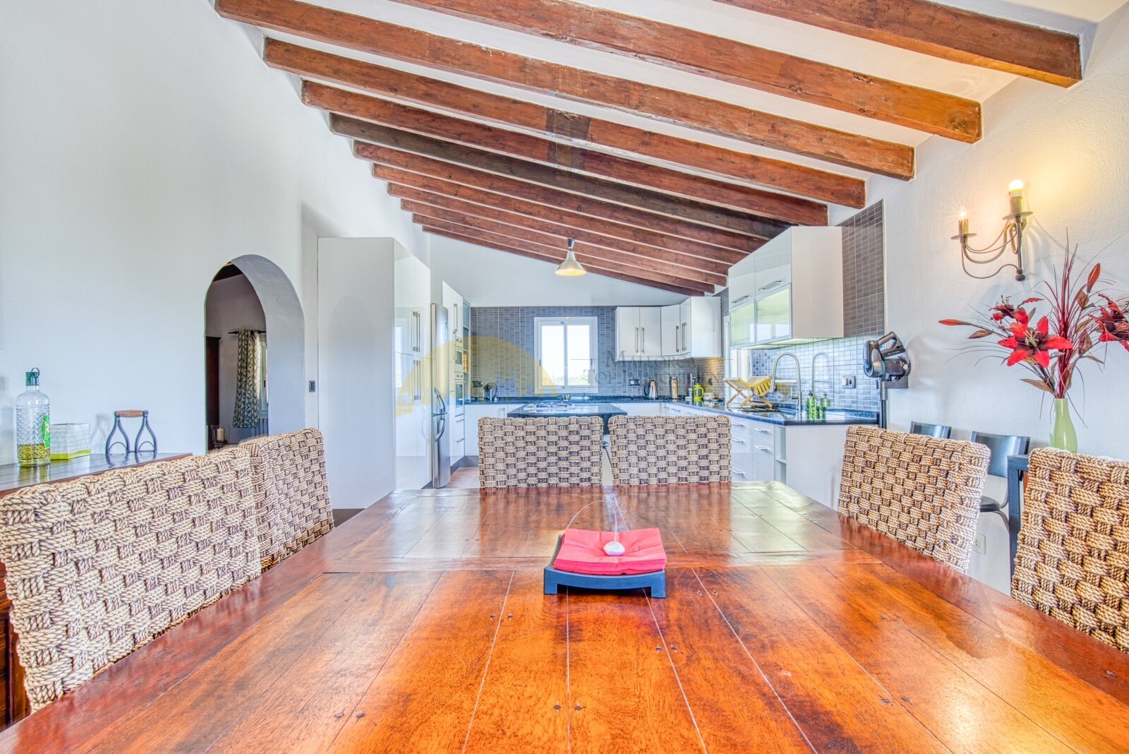 Open living and dining area with rustic wooden beams and a seamless connection to the kitchen Open living and dining area with rustic wooden beams and a seamless connection to the kitchen