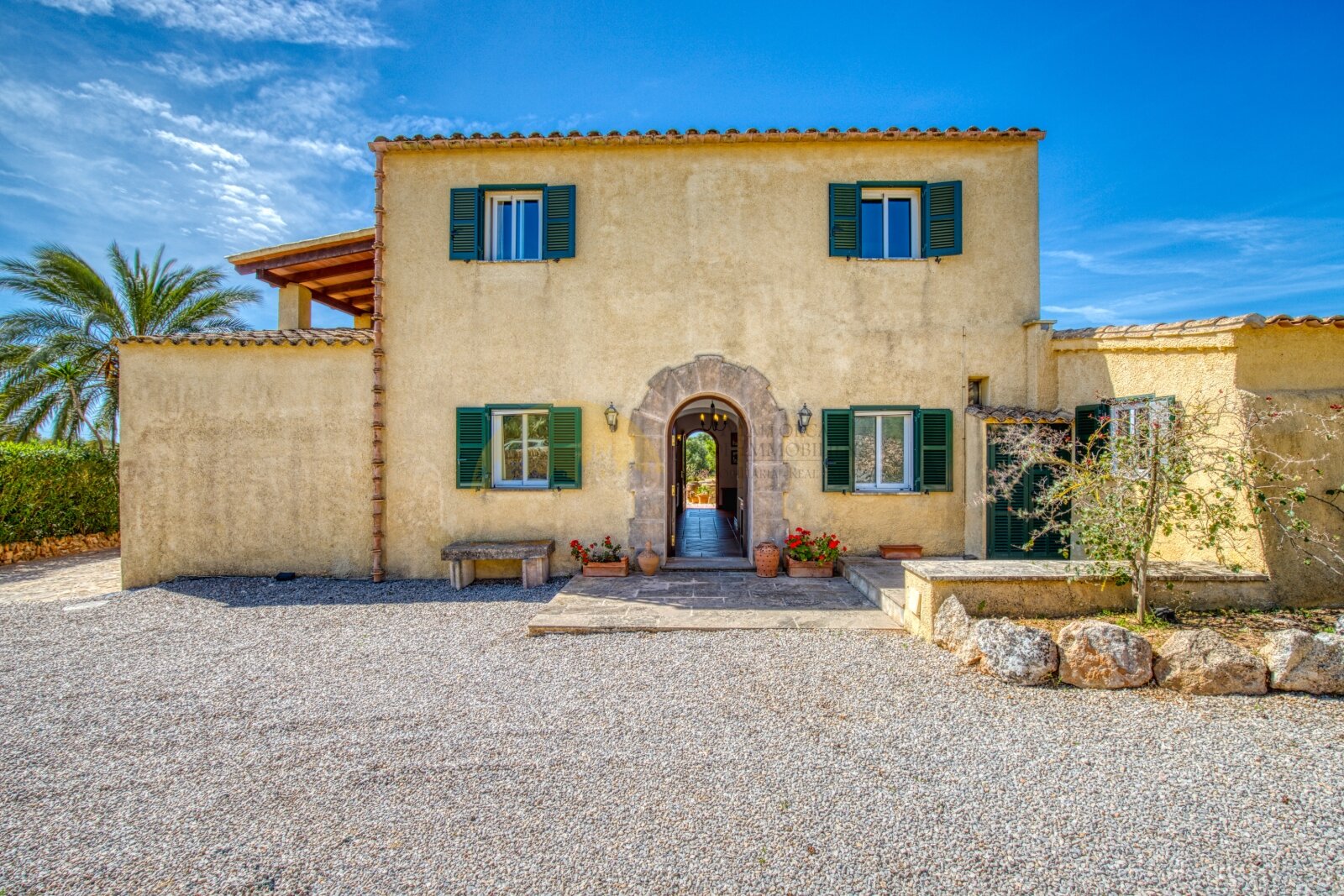 Authentic country house facade with a distinctive stone entrance and pergola covering Authentic country house facade with a distinctive stone entrance and pergola covering