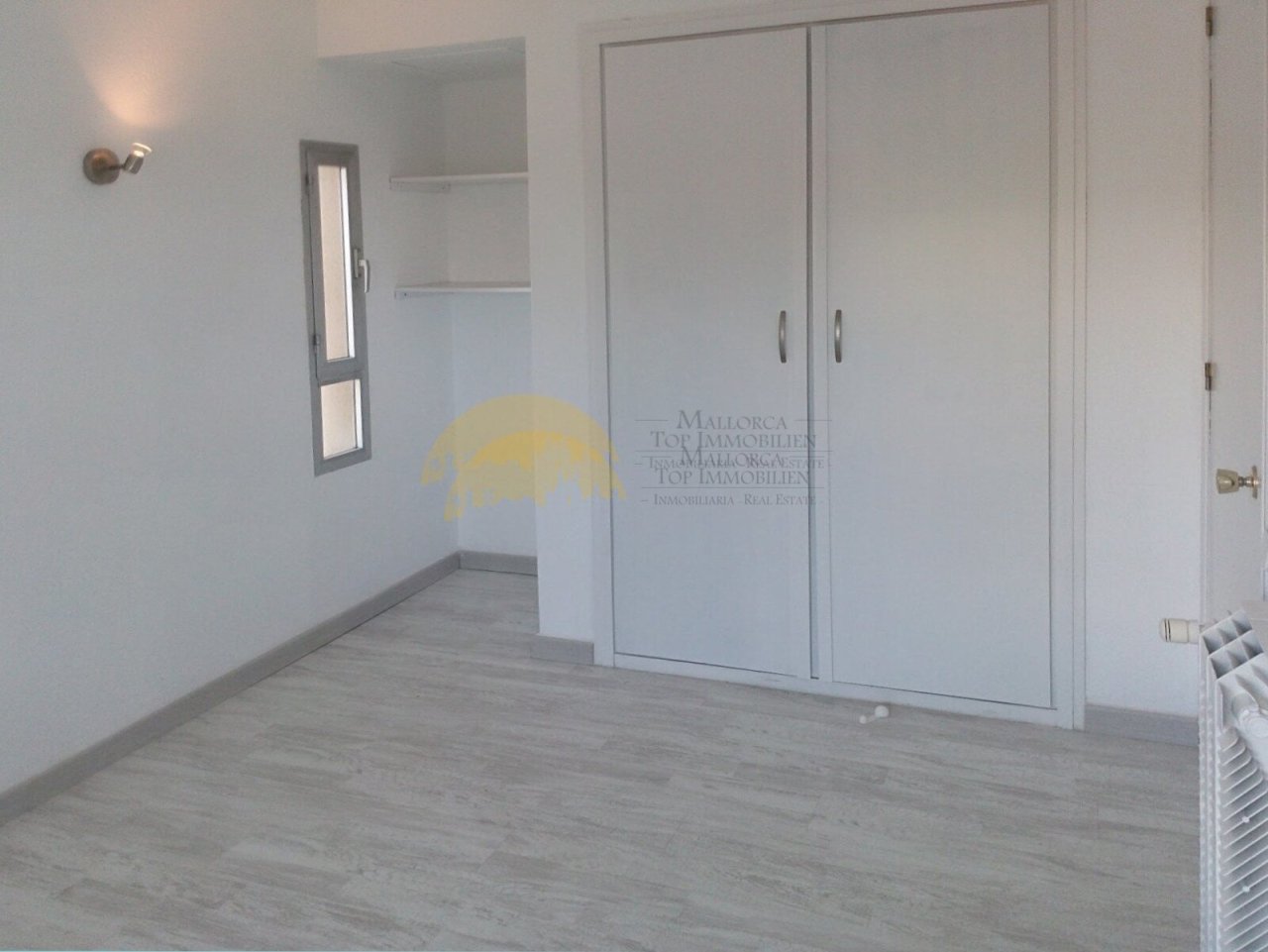 Spacious bedroom with wall-integrated wardrobe systems and practical layout