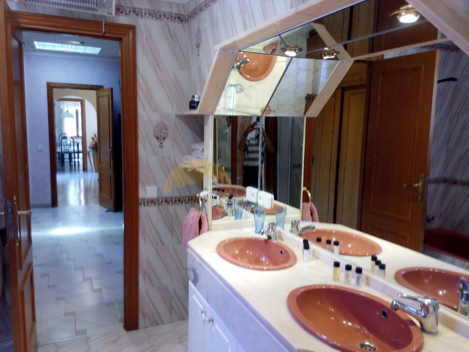 Elegant double sink bathroom with large mirrors and skylights for optimal brightness