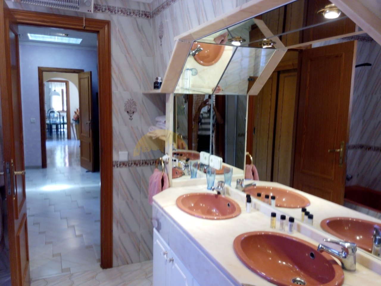 Elegant double sink bathroom with large mirrors and skylights for optimal brightness