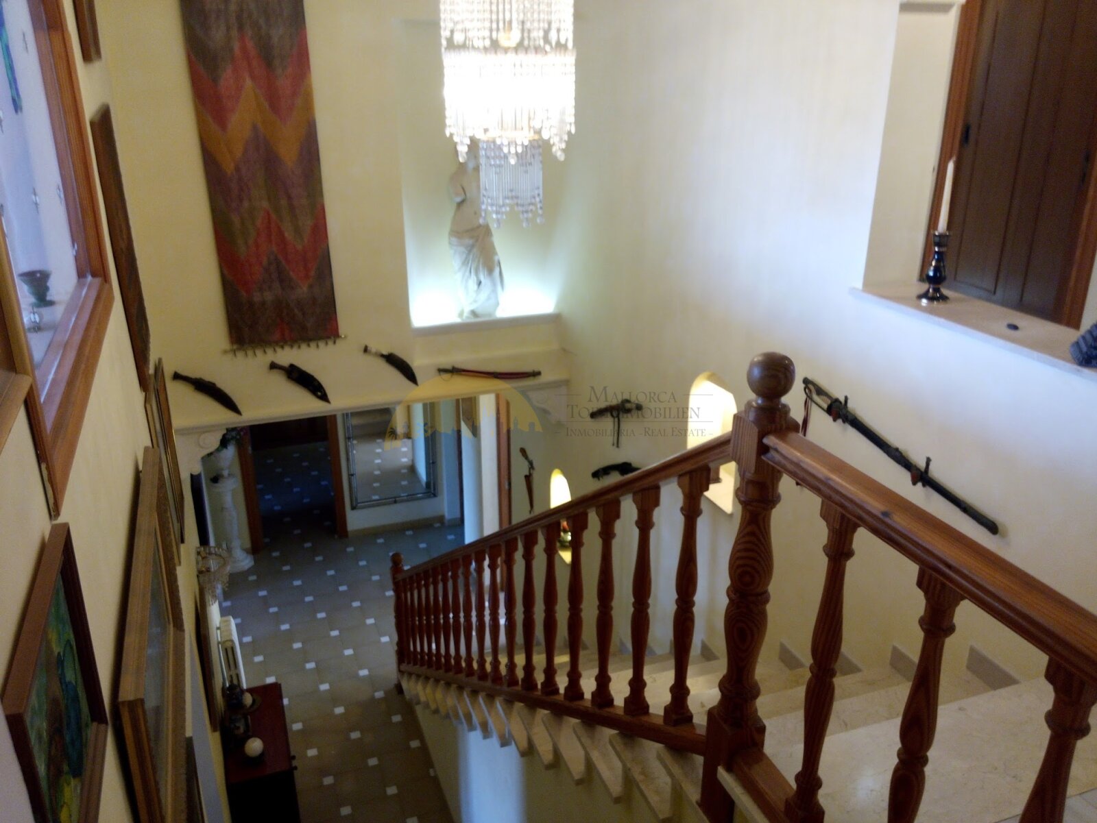Brightly lit staircase with elegant wooden balustrade and open gallery connection
